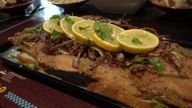 Kurdish deep fried turkey meat served with lemon, national cuisine of Kurdistan, Iraq, close up slowmotion