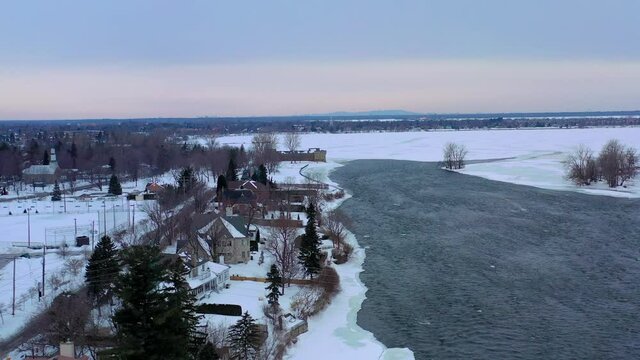 drone flyng with river in winter time approaching at a lake and ful of snow