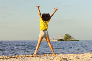 Obraz premium happy young woman jumping on the beach