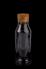 Clear Glass Liquor, Rum or Cognac Bottle is Partially Filled.Close Up Isolated on Black Background.