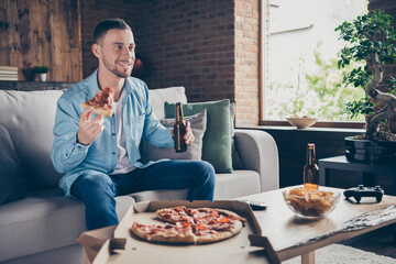 Profile photo of domestic handsome guy stay home good mood quarantine time watch television eat pizza drink beer sit cozy sofa football season modern interior living room indoors