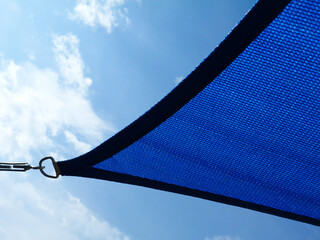 fabric sun shade and awning over patio or balcony. sun sail, spanning above city terrace. blue sky...