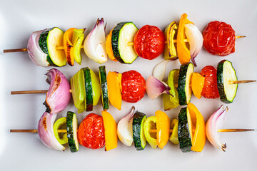 Grilled skewers vegetables on gray rectangular plate. Vegan food concept.