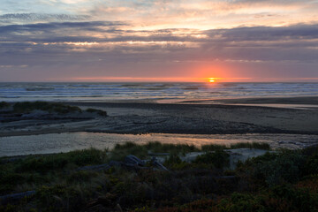 Amazing beach sunset with endless horizon. Colorful dramatic sky reflects in ocean water. Good for background