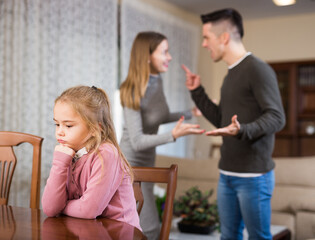 Unhappy preteen girl while parents quarreling