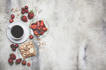 Breakfast sweet fruit toasts with coffee on the table, top view.