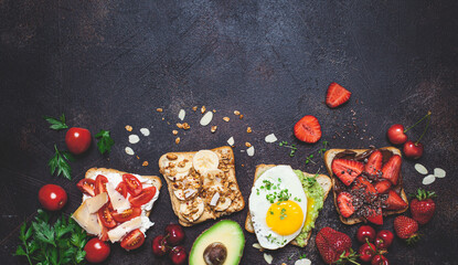 Breakfast different toasts with berries, cheese, egg and fruit, dark background, top view. Breakfast table concept.