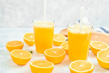 Glass of freshly squeezed orange juice and slices of orange fruit isolated on white background