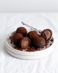 Vegetarian Chocolate Truffles With Raw Cocoa And Dates. Closeup View Of Pile Of Homemade Chocolate Truffles on white background. Chocolate Energy Balls