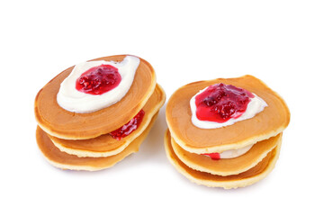 Stacks of pancakes with sour cream and raspberry jam isolated on white background