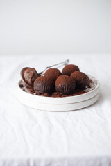 Vegetarian Chocolate Truffles With Raw Cocoa And Dates. Closeup View Of Pile Of Homemade Chocolate Truffles on white background. Chocolate Energy Balls