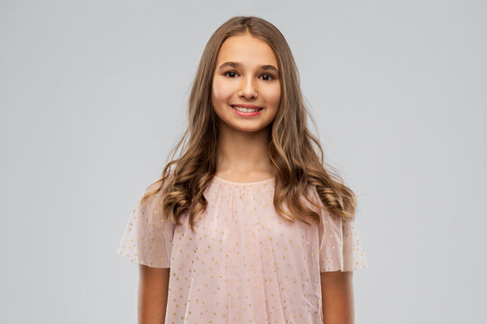 fashion and people concept - smiling young teenage girl in party dress over grey background