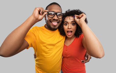 relationships, vision and people concept - happy african american couple in glasses hugging over...