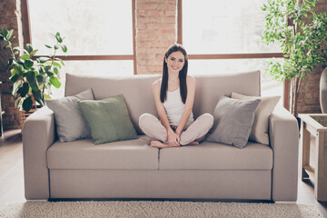 Obraz premium Full size photo of attractive pretty girl sit divan legs crossed enjoy holiday free time in house indoors