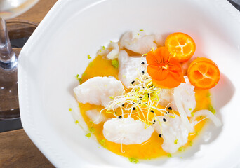 Ceviche from hake with spicy avocado sauce and cumquat at plate