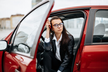 The girl in the car. A woman in a parking lot sits in a auto.