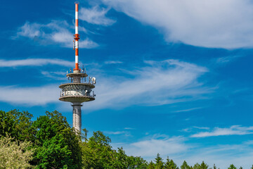 A radio tower with a blue sky and a few white clouds.