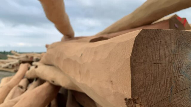 Clean beautiful wooden logs on the pile. Logs stored for a cottage build. Stack of peeled wooden alder logs used in building industry. Building wooden log house or cabin. Large timber trunks. 