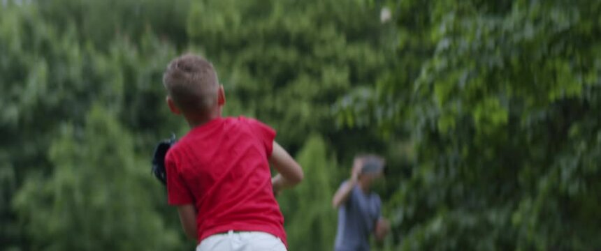 MED Two brothers or friends playing baseball catch in the park. Family time spent together. Shot with 2x Anamorphic lens