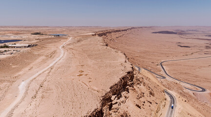 aerial panorama of the north rim of the makhtesh ramon crater in israel facing northeast showing a solar farm and the highway to eilat