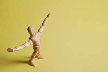 黄色背景で左寄りに立って両手を広げて喜びを表すモデル人形
