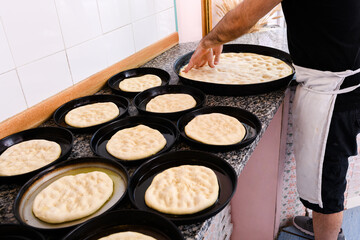 Chef stretching portions of pizza dough