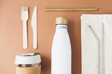 Stylish reusable eco friendly items on brown background.
