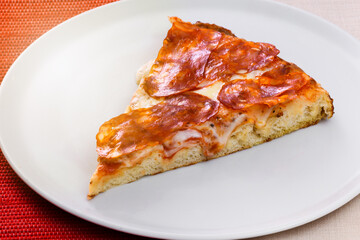 Slice of traditional Italian salami pizza