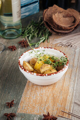 Baked young potatoes in a bowl on a wooden table