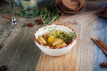 Baked young potatoes in a bowl on a wooden table