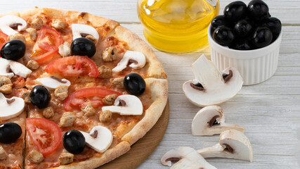 homemade pizza with chicken, mushrooms and olives on wooden background