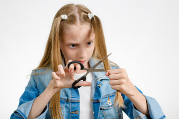 A girl holds scissors near her hair. Scissor Focus
