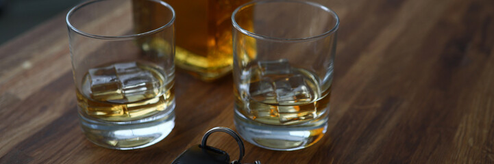 Car key lies on table next to bottle alcohol. Permissible rate alcohol while driving. Drivers are tempted to drink strong drinks. Identify drunken motorists. Drunk driving. Checking for intoxication