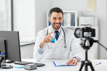 healthcare, medicine and blogging concept - happy smiling male doctor with camera and hand...