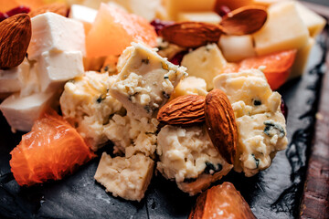 Various cheese and almond on a serving board, close-up.