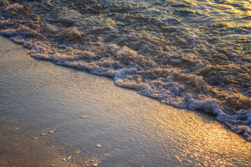 Wave of the sea on the sand beach. Soft focus on the picture