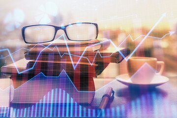 Financial graph hologram with glasses on the table background. Concept of business. Double exposure.