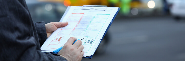 Man fills out insurance form on movement vehicle. Employee provides basis for insurance. Traffic...