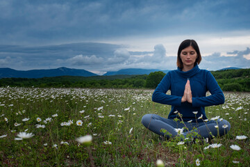 A young woman doing yoga in the field.