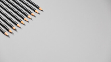 Simple graphite pencils on grey background. Black pencils, space for text
