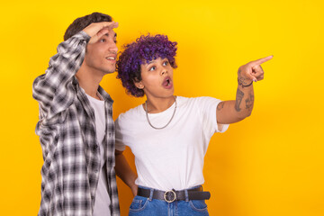 young couple pointing isolated on background