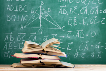 Education concept - books on the desk in the auditorium