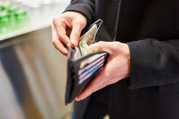 Mann beim Bezahlen mit Geldschein aus Brieftasche