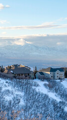 Vertical frame Houses on snowy mountain overlooking Wasatch Mountains and residential valley