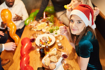 Frau mit Nikolausmütze auf einer Weihnachtsfeier