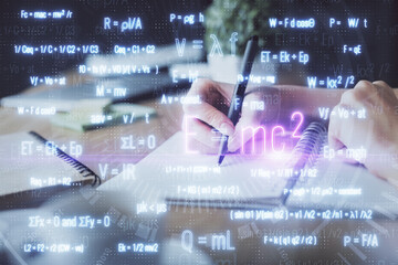 Science formula hologram over woman's hands taking notes background. Concept of study. Double exposure