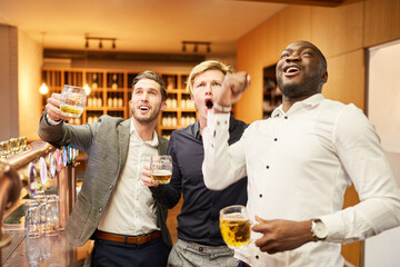 Fans schauen gemeinsam ein Fußballspiel im Pub