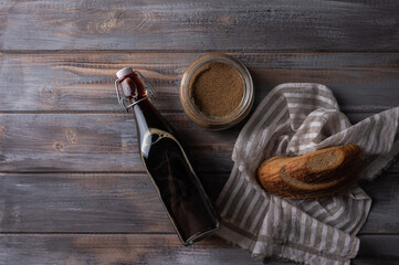 Fototapeta na wymiar Top view homemade tradishional russian kvass in glass bottle with leaven and bread. Wonderful healthy refreshing drink for summer