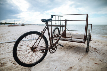 Old bicycle three wheeled on the beach in Mexico, Progreso.