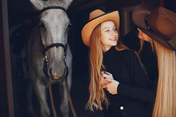Fototapeta na wymiar Girls with a horse. Women in a ranch. Blonde in a black sweater